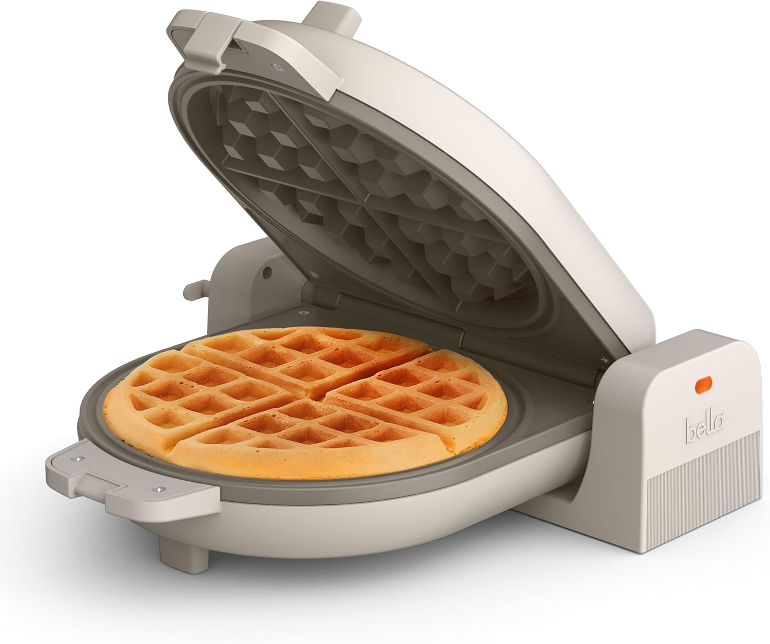 Golden Belgian waffles beside a stainless steel waffle maker