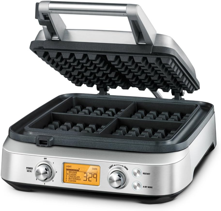 Golden Belgian waffles beside a stainless steel waffle maker